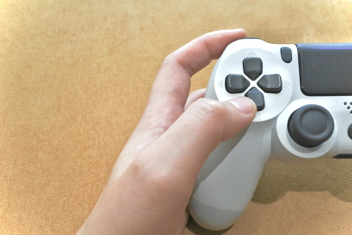 白いゲームコントローラーを握る手