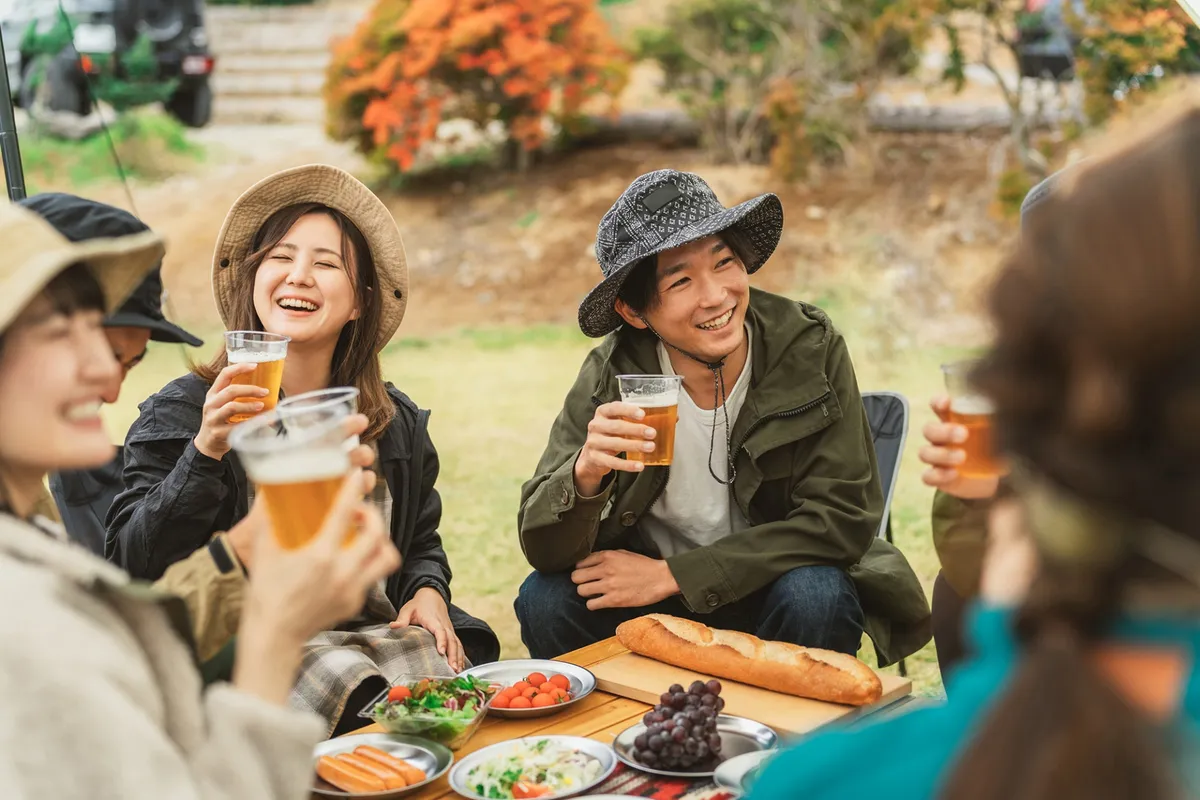 アウトドアで乾杯する友人グループ
