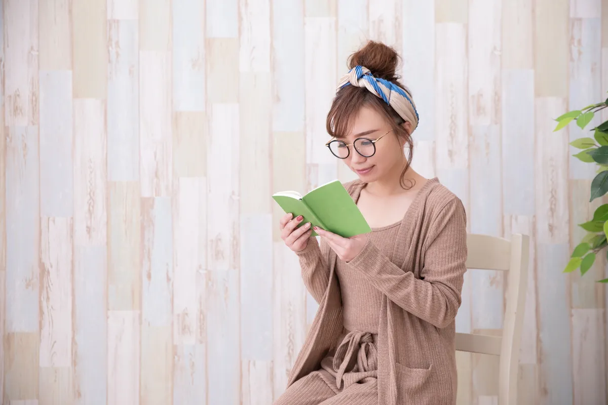 メガネをかけて本を読む女性