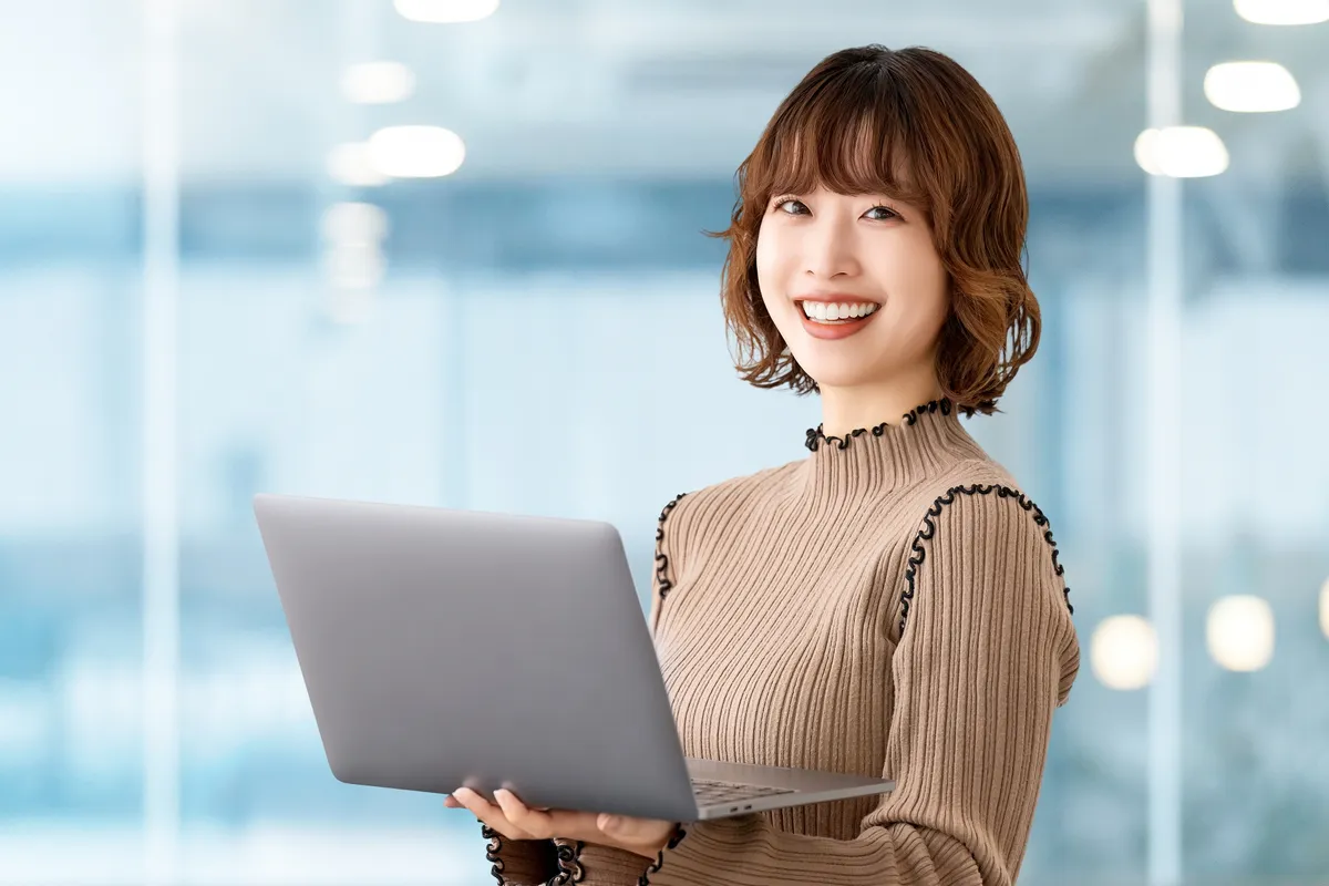 ノートPCを持つ笑顔の女性