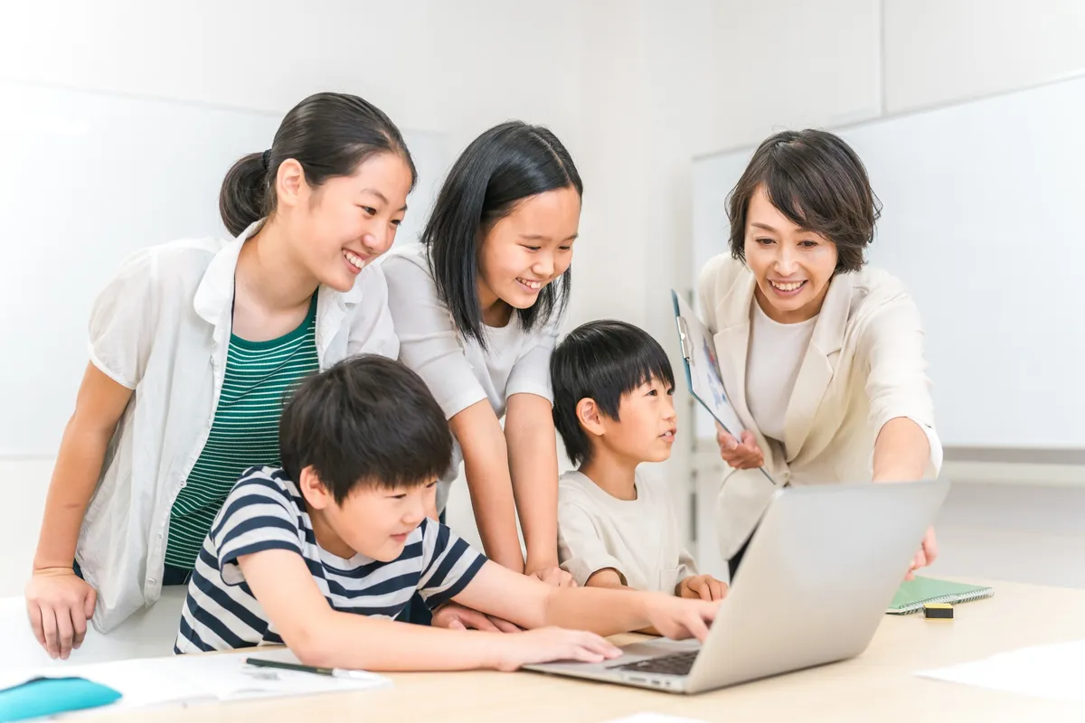 ノートPCで学ぶ子供達と先生