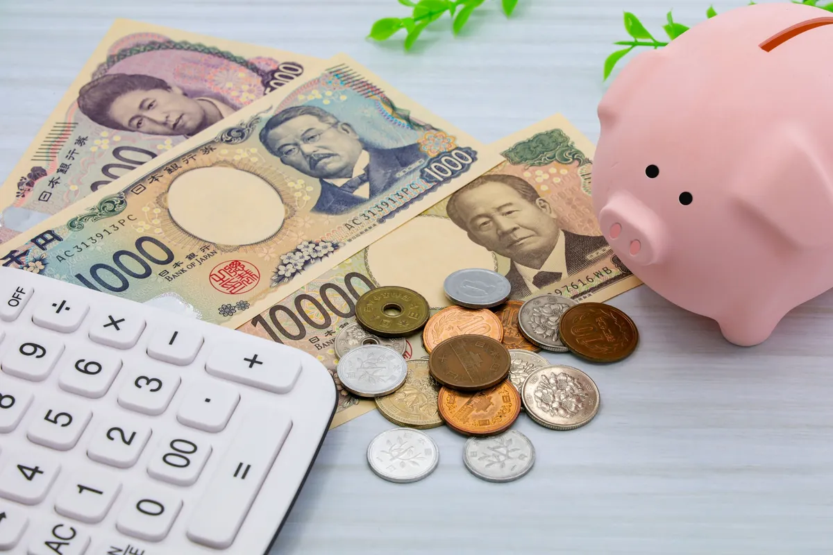 千円札と豚の貯金箱と電卓
