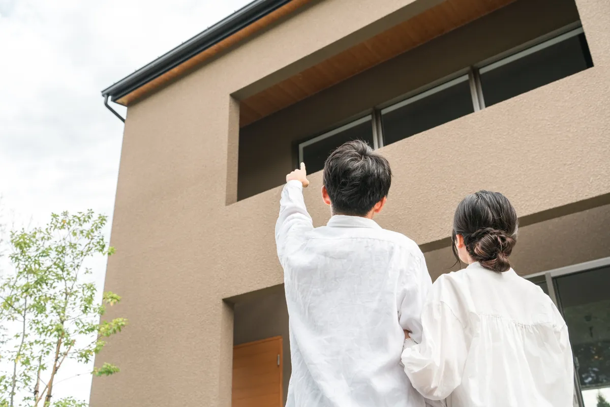 新築の家を見上げる夫婦