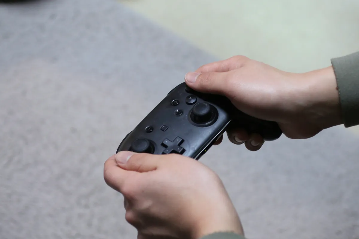 黒いプロコンを握る手元