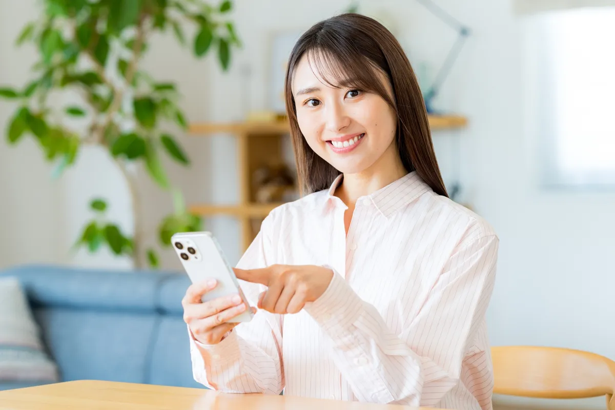 スマホを操作する日本人女性の笑顔