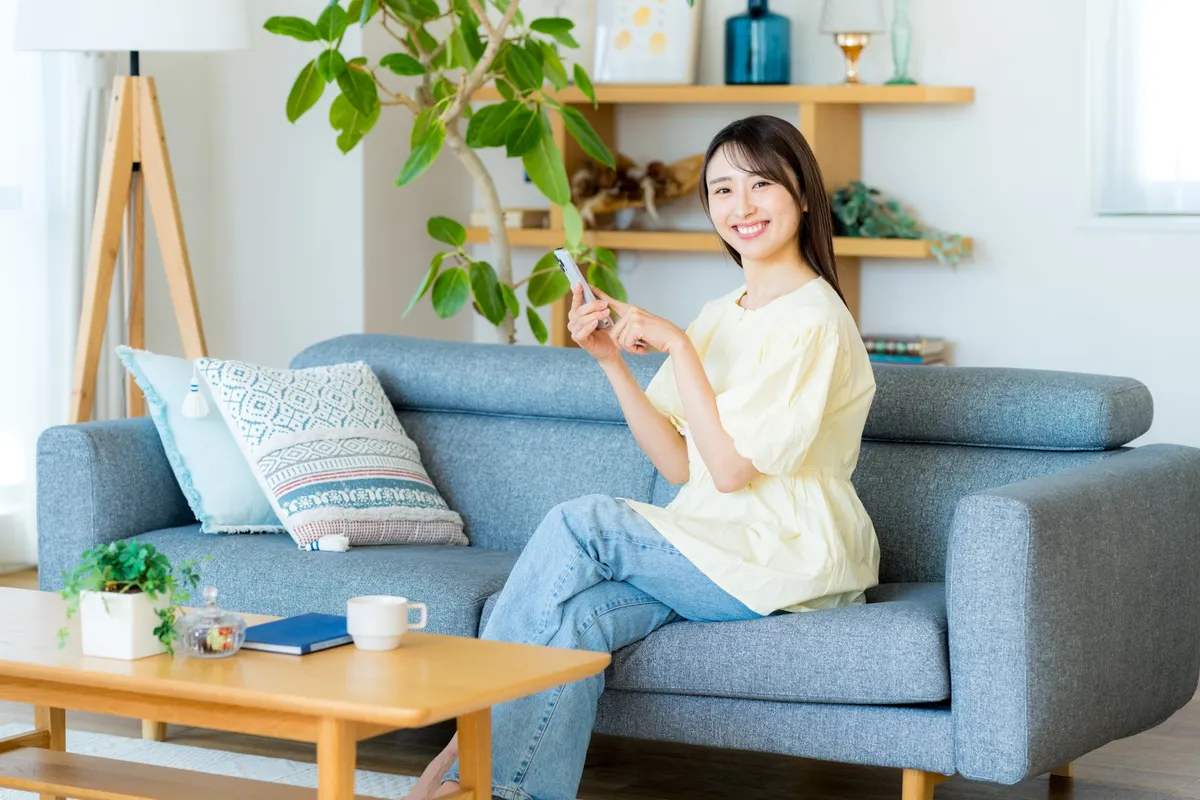ソファでスマホを操作する女性