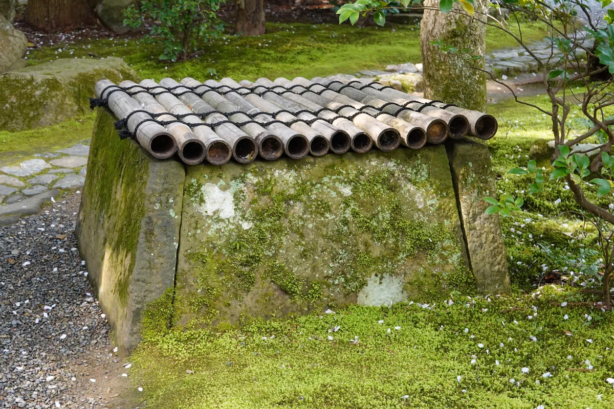 竹屋根の井戸のある日本庭園
