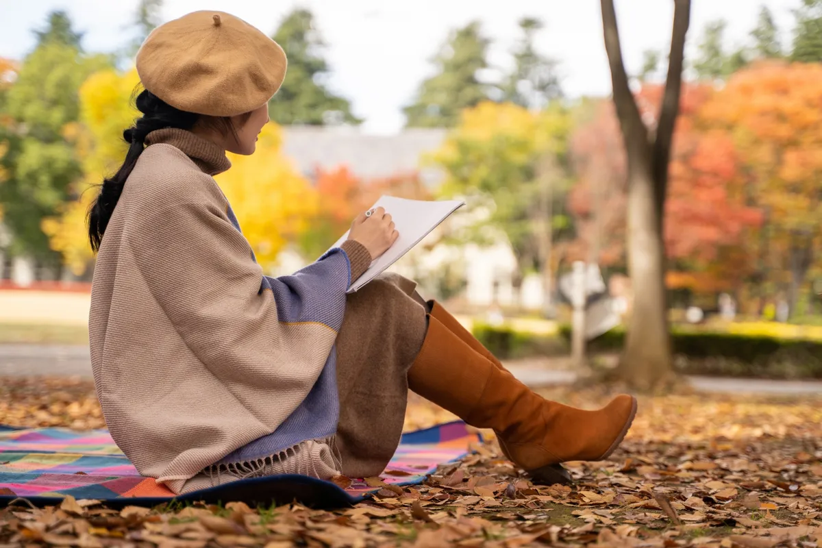 公園で絵を描く秋の女性